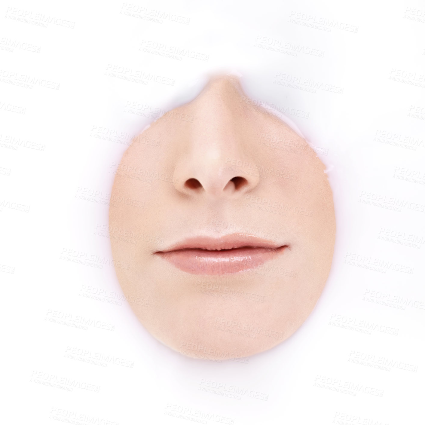 Buy stock photo Studio shot of a woman's mouth and nose emerging from milky liquid