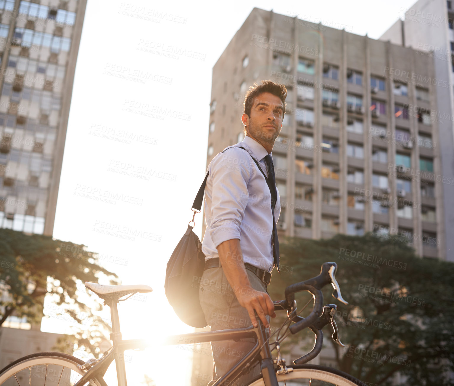 Buy stock photo Shot of a businessman commuting to work with his bicycle