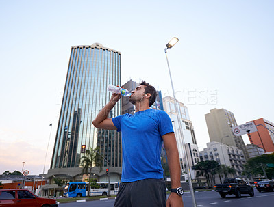 Buy stock photo Hydration, break and man drinking water in city for exercise, running or marathon with bottle. Thirsty, workout and male athlete resting for body recovery, fatigue or summer training in urban town