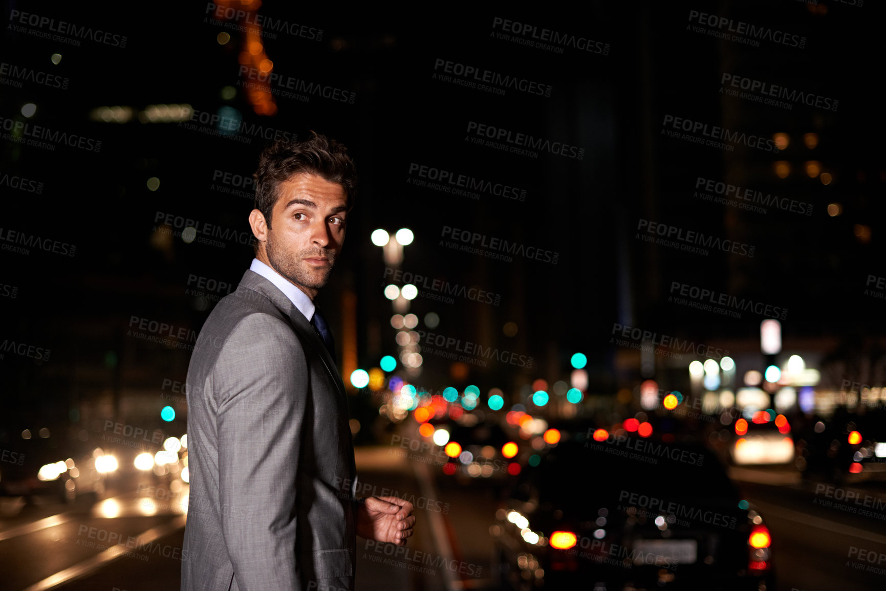 Buy stock photo A handsome businessman crossing a busy city street at night