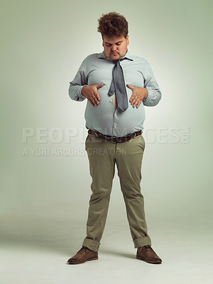 Buy stock photo Shot of an overweight man holding his rotund belly