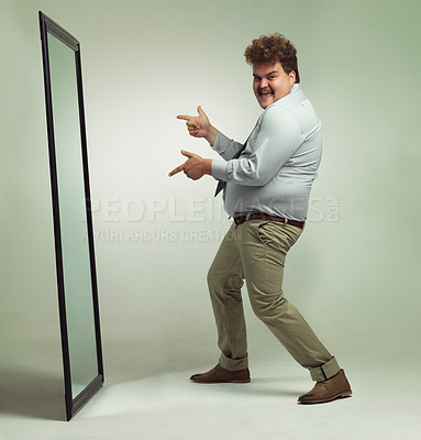 Buy stock photo Mirror, portrait and man with smile pointing, double chin and happiness for reflection in studio. Overweight, plus size and male person with obesity, comic and excited to change unhealthy life