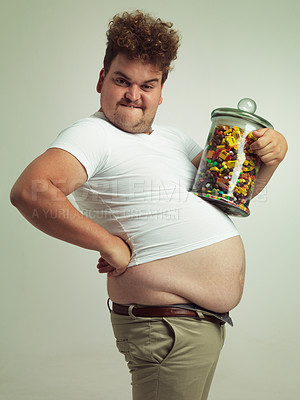 Buy stock photo Cropped shot of an overweight man holding a large jar of candy