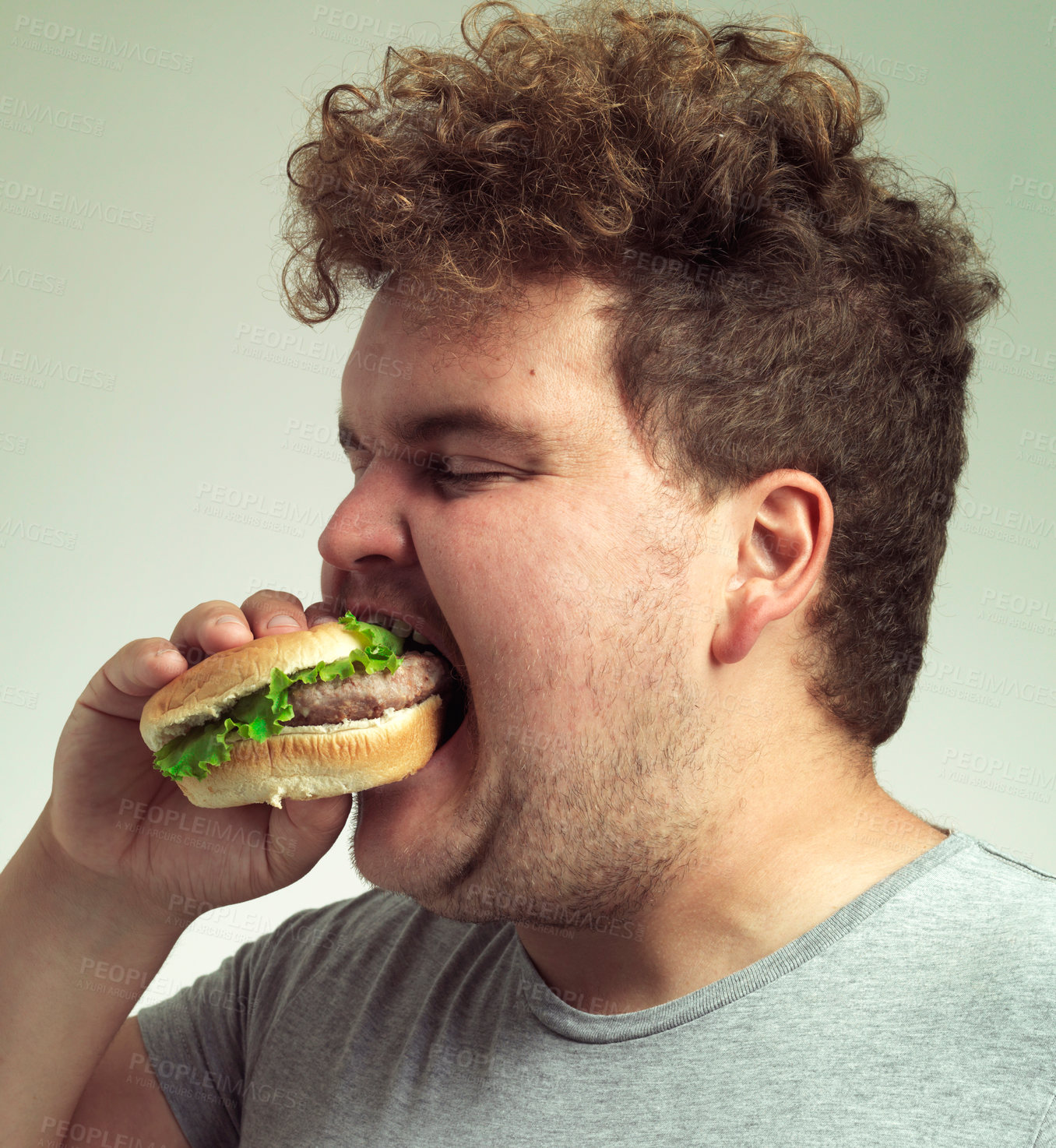 Buy stock photo Obesity, weight gain and fast food for man in studio with hamburger for unhealthy eating,plus size and greed. Overweight person with burger in mouth and double chin for delicious, humor and comedy 