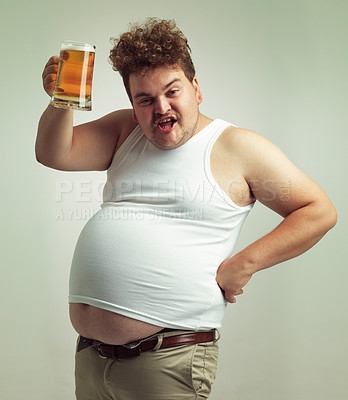 Buy stock photo Shot of an overweight man raising his beer in toast
