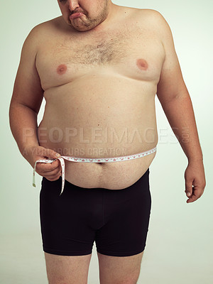 Buy stock photo Man, plus size and disappointed on stomach with measurement in studio on white background with tape for weight loss and progress. Sadness, fitness and body with self care to monitor health and shape.