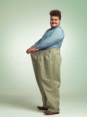 Buy stock photo Happy man, plus size and weight loss with pants for measurement or waist on a studio background. Male person with smile for healthy diet, nutrition and oversize in fashion or clothing on mockup space