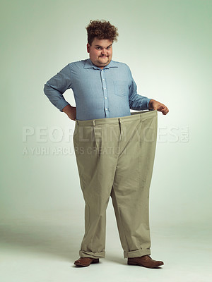 Buy stock photo Happy man, portrait and plus size with pants for waist, weight loss or measurement on a studio background. Male person with smile for healthy diet, obesity or overweight clothing on mockup space
