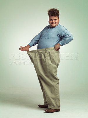 Buy stock photo Happy man, portrait and plus size with weight loss or pants for measurement or waist on a studio background. Male person with smile for healthy diet, obesity or overweight in clothing on mockup space