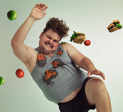 Buy stock photo Shot of an overweight man dodging food being thrown at him