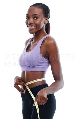Buy stock photo An isolated portrait of a sporty young woman measuring her waist with a measuring tape