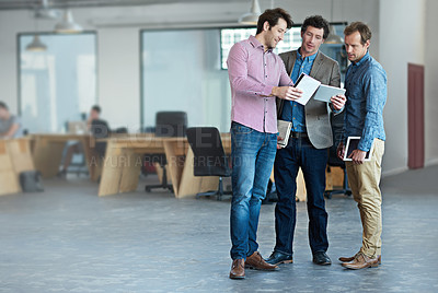 Buy stock photo Shot of a group of male coworkers taking over a digital tablet in an office