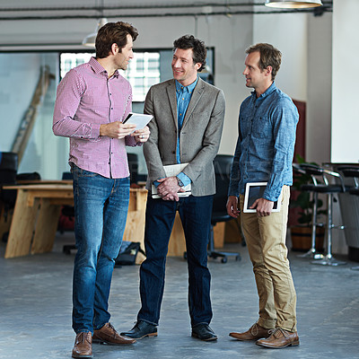 Buy stock photo Male colleagues standing together and talking while taking a break from work. Modern architect team of men planning a teamwork collaboration. Confident architecture workers talk about a design inside