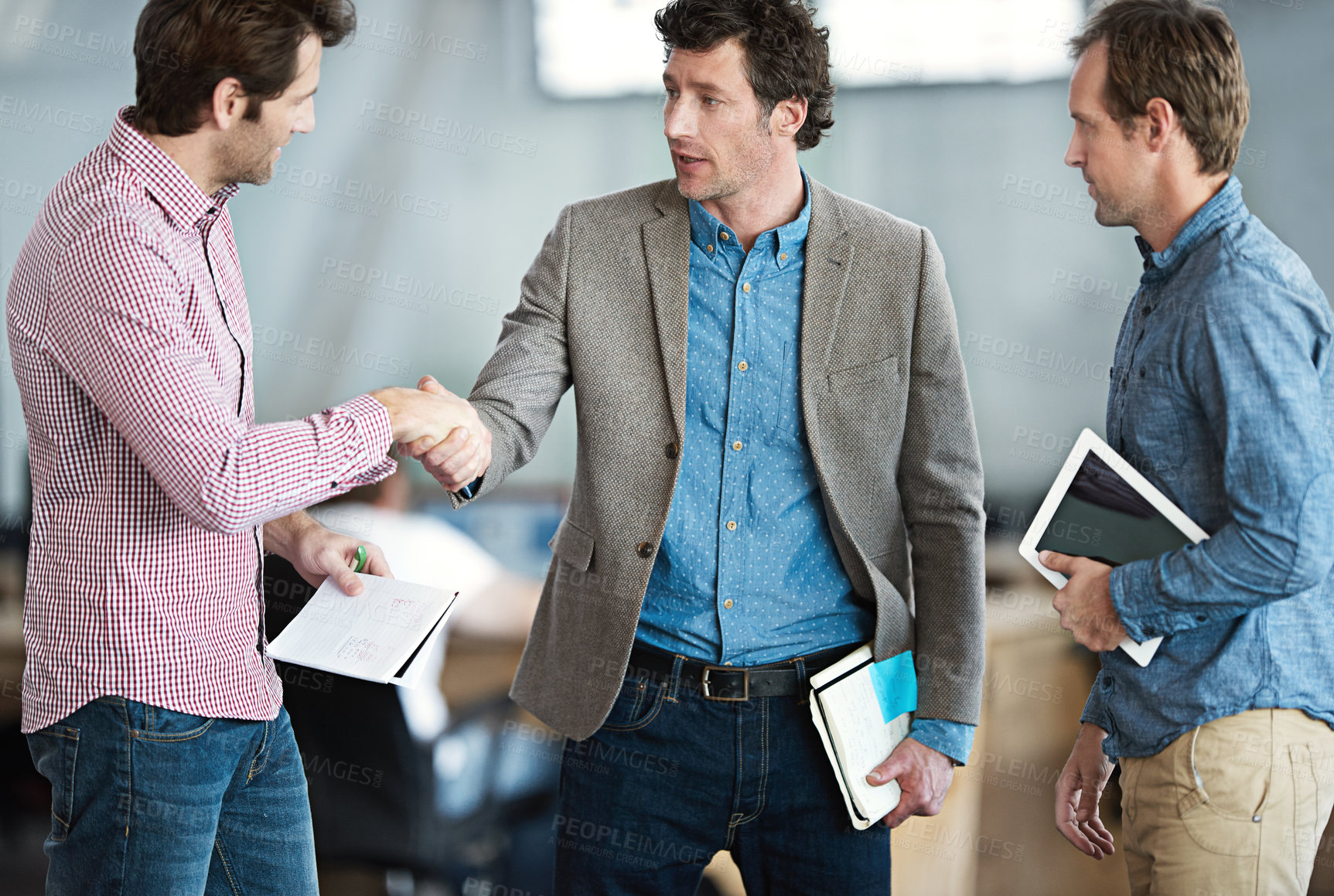 Buy stock photo Shot of two coworkers shaking hands in an office