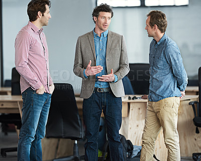 Buy stock photo Shot of a group of male coworkers talking together in an office