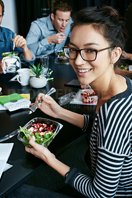 Buy stock photo Portrait of a young office worker eating lunch with coworkers at a boardroom table