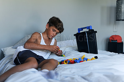Buy stock photo Happy, young boy and toys, playing on bed at home for learning, development and motor skills. Relax, male child and building blocks for growth and education for creative thinking and problem solving