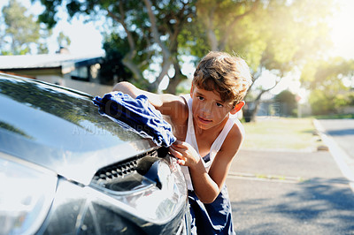Buy stock photo Cropped shot of a young boy washing a car outside