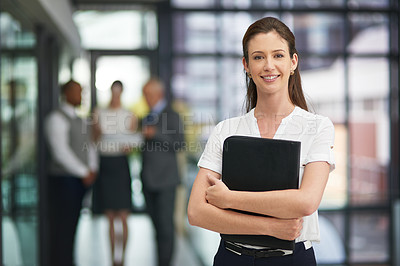 Buy stock photo Portrait of a young businesswoman standing in the office with his colleagues in the background