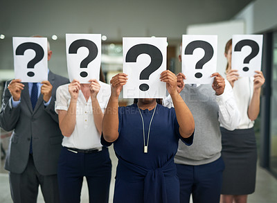 Buy stock photo Shot of a group of businesspeople holding questions marks in front of their faces