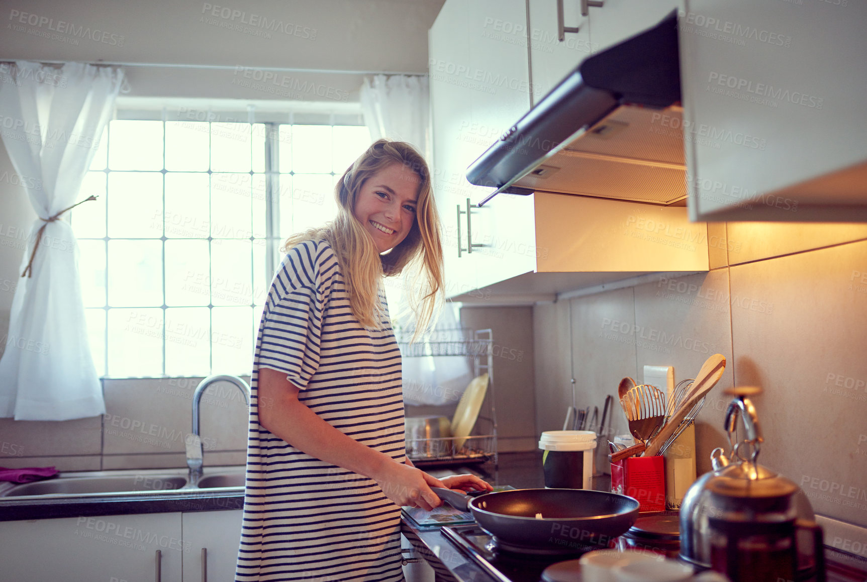 Buy stock photo Portrait of an attractive young woman cooking in her kitchen