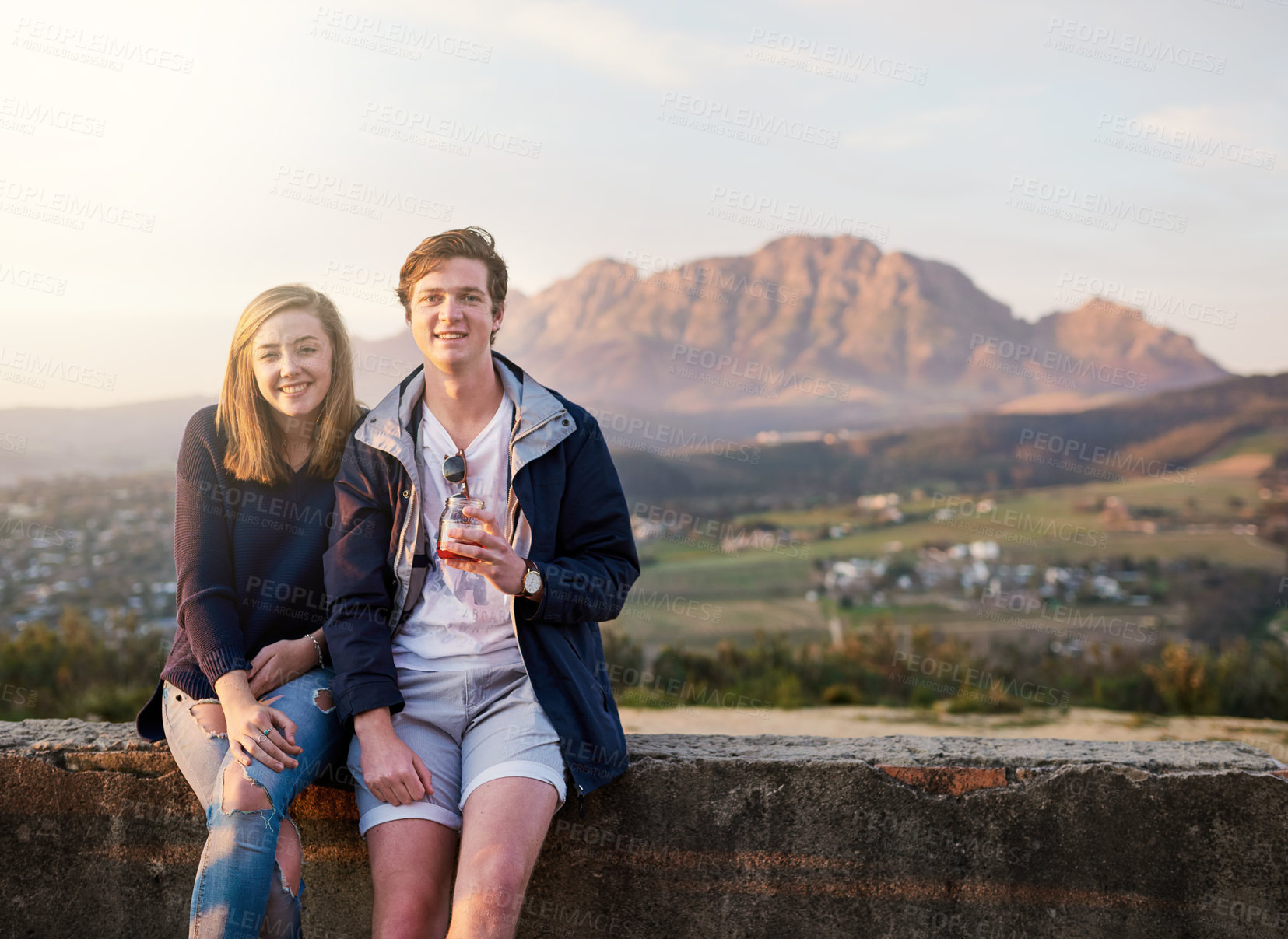 Buy stock photo Portrait of a young couple enjoying a drink together outside