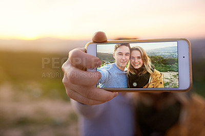 Buy stock photo Shot of an happy young couple taking a selfie outdoors