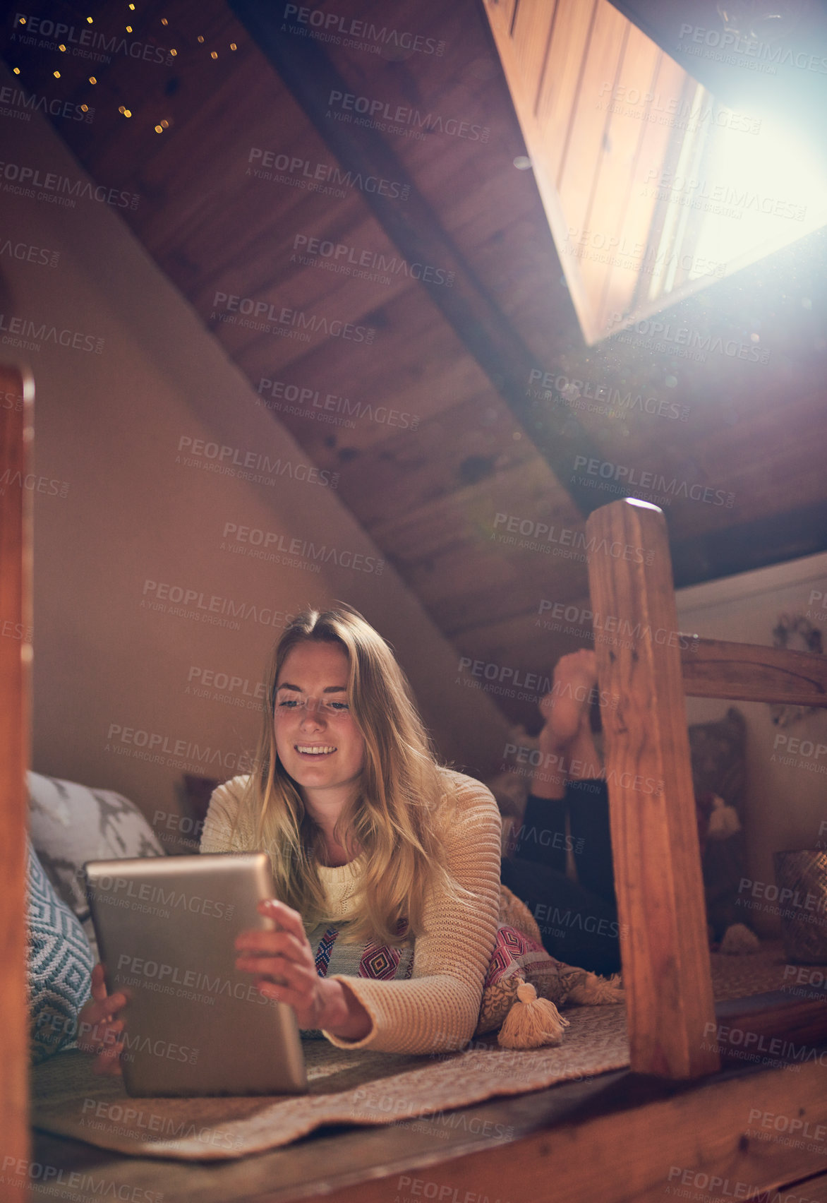 Buy stock photo Shot of a young woman using her tablet while relaxing in her bedroom at home