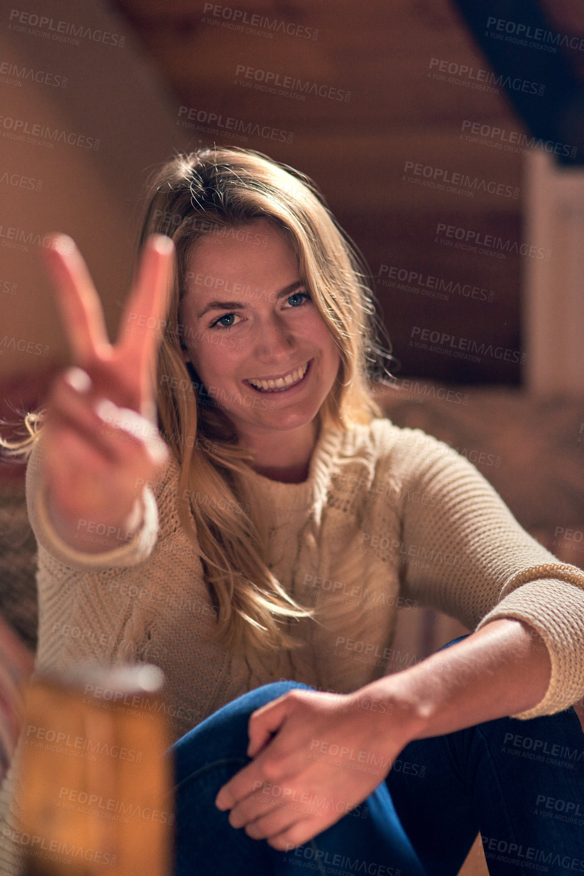 Buy stock photo Portrait of a young woman giving a peace sign while relaxing in her bedroom at home
