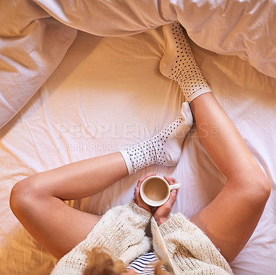 Buy stock photo High angle shot of an unidentifiable woman drinking coffee while sitting on her bed