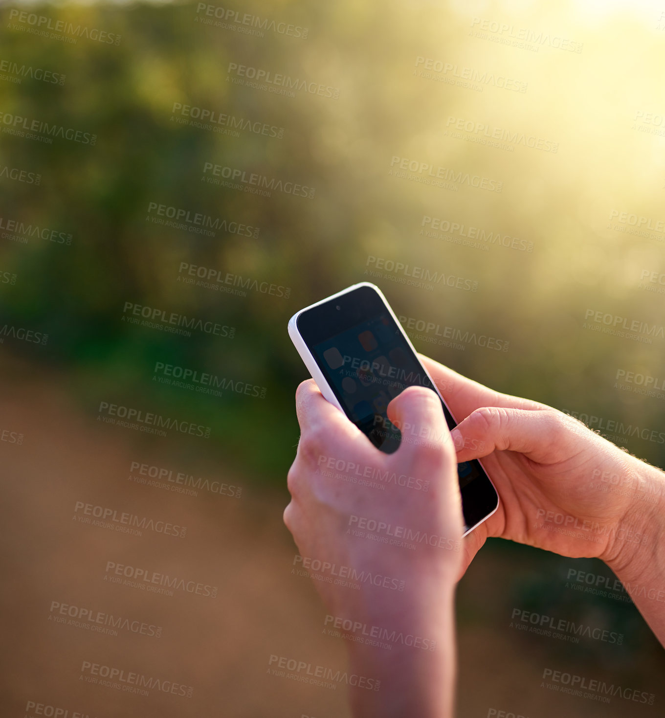 Buy stock photo Shot of an unidentifiable woman sending a text message while in a park