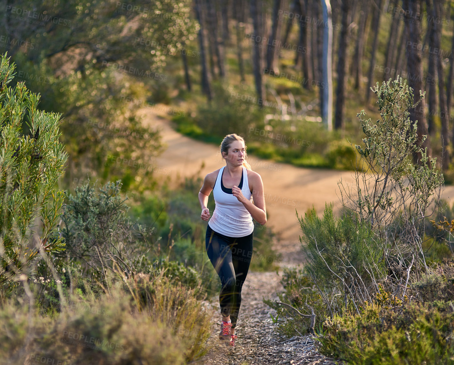 Buy stock photo Shot of an attractive young woman exercising outdoors