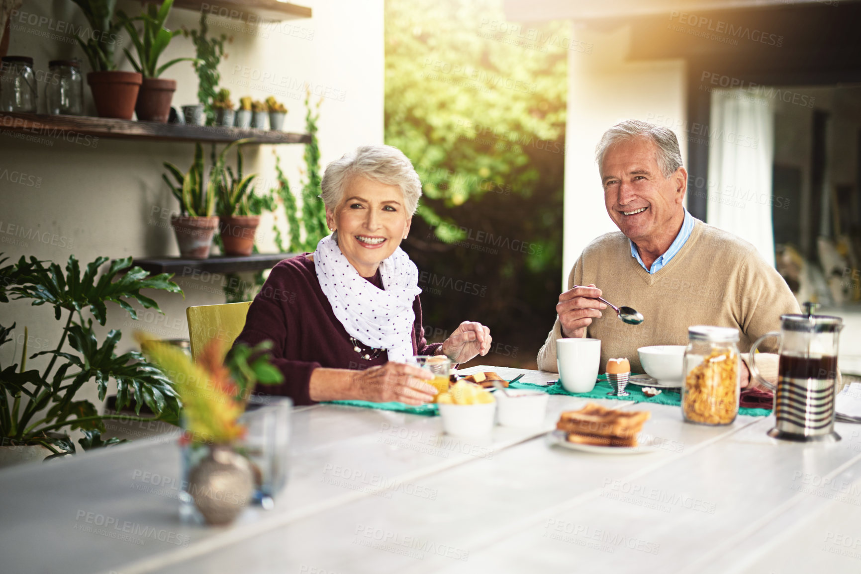 Buy stock photo Portrait of a happy senior couple enjoying breakfast together at home