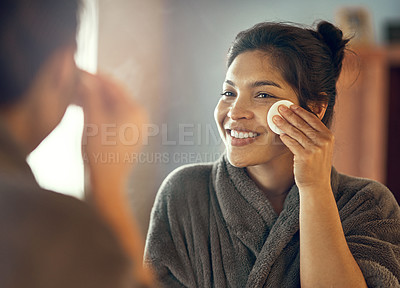 Buy stock photo Shot of a smiling young woman taking care of her skin at home