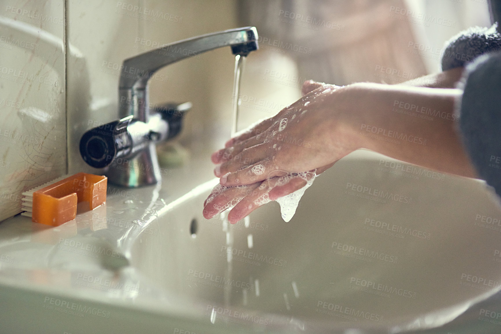 Buy stock photo Shot of an unidentifiable young woman washing her hands by the bathroom sink