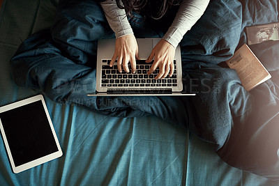 Buy stock photo High angle shot of an unidentifiable woman using her laptop while sitting in bed