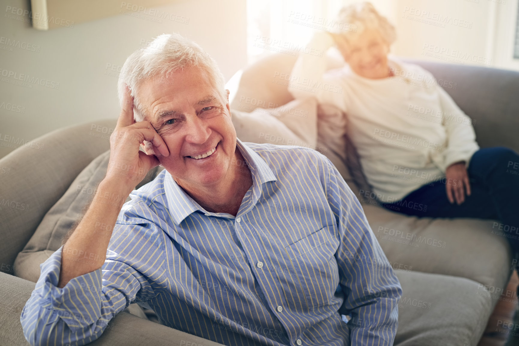 Buy stock photo Portrait of a senior man relaxing at home with his wife in the background