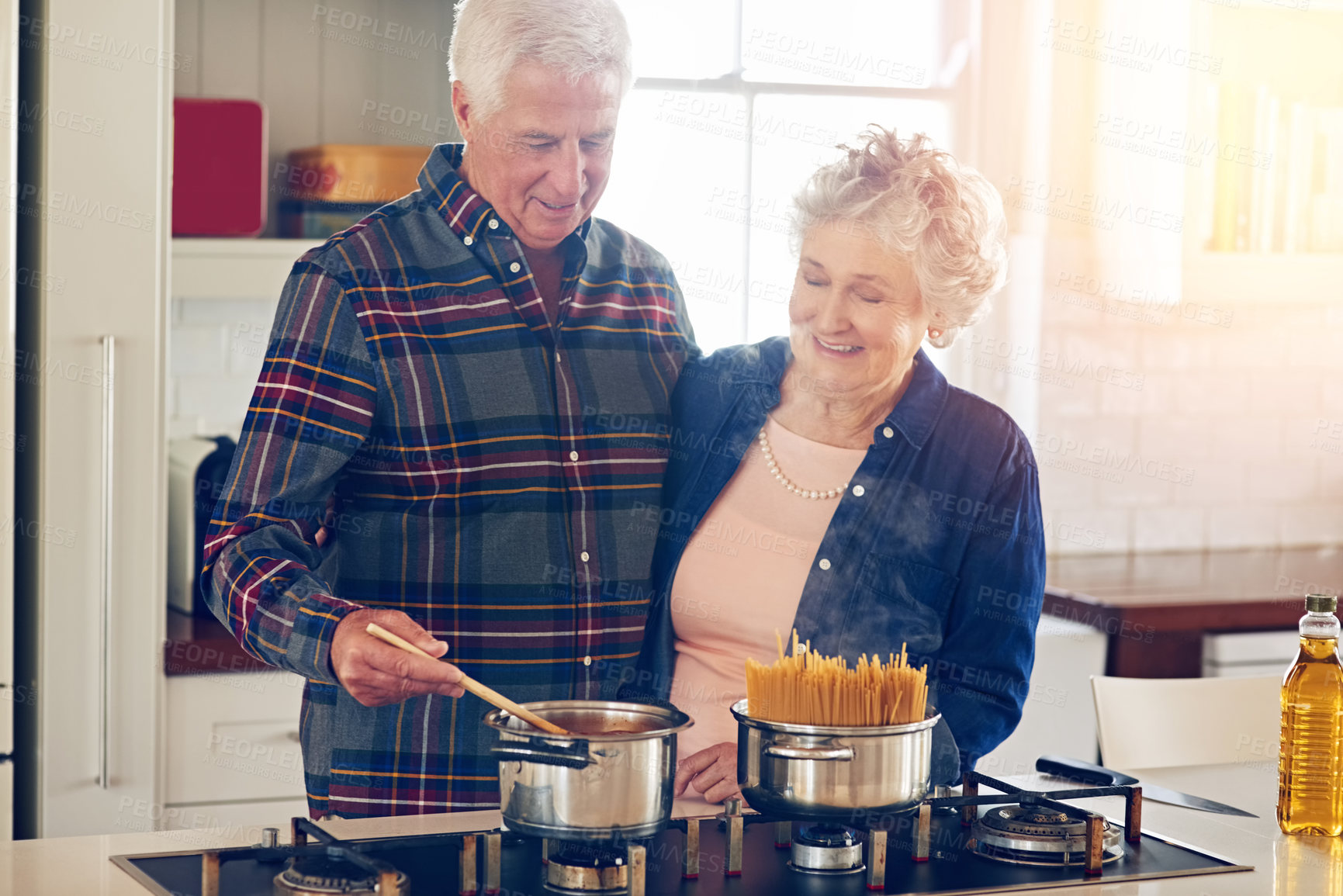 Buy stock photo Cropped shot of a senior couple cooking together in their kitchen at home