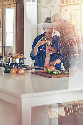Buy stock photo Shot of a smiling senior couple cooking together in their kitchen at home