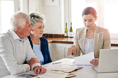 Buy stock photo Cropped shot of a senior couple getting advice from their financial consultant