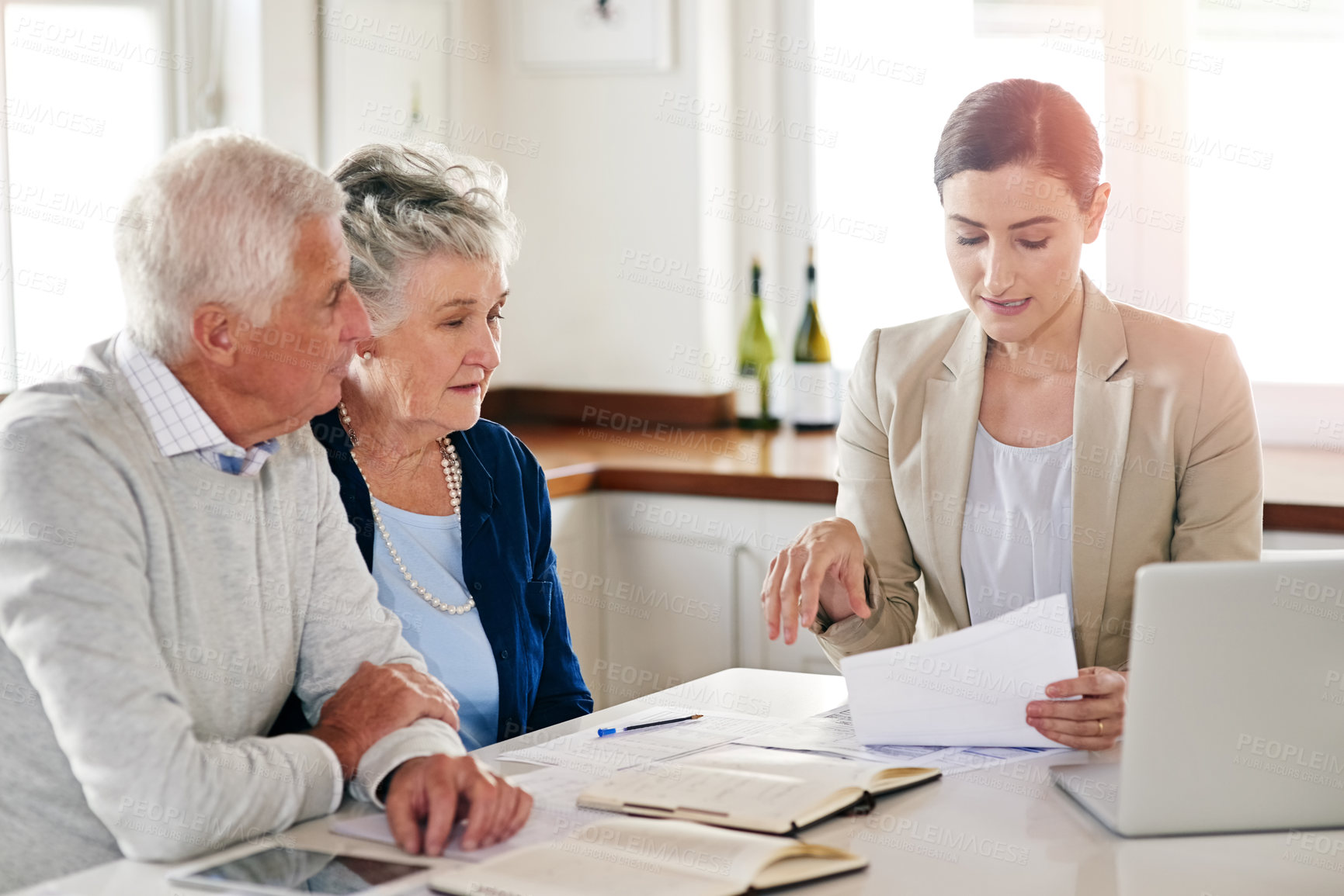 Buy stock photo Cropped shot of a senior couple getting advice from their financial consultant