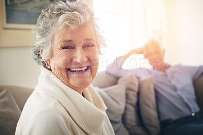 Buy stock photo Portrait of a senior woman relaxing at home with her husband in the background