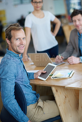 Buy stock photo Smiling marketing manager browsing the internet on a digital tablet in an office. Handsome and happy professional researching creative ideas to promote and advertise a startup on social media 
