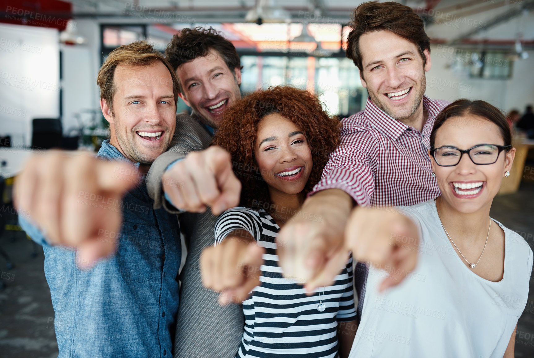 Buy stock photo Portrait of a group of smiling coworkers pointing at the camera while standing in an office