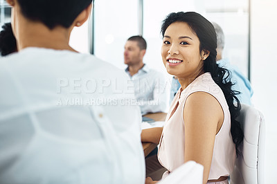 Buy stock photo Portrait of a young businesswoman sitting in a meeting alongside her colleagues