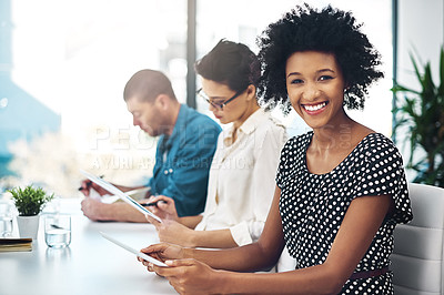 Buy stock photo Portrait of a young businesswoman working in an office with her colleagues in the background