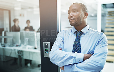Buy stock photo Shot of a young businessman standing with her arms crossed in an office doorway