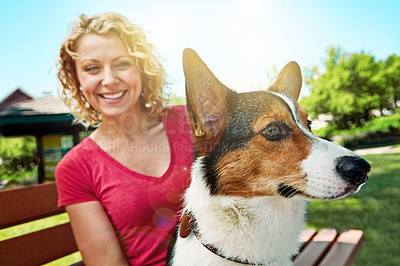 Buy stock photo Shot of a young woman bonding with her dog in the park