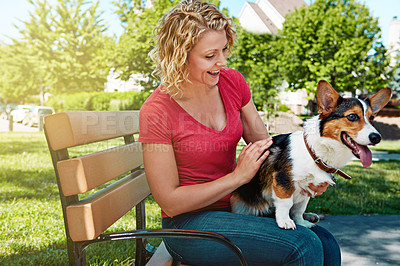 Buy stock photo Shot of a young woman bonding with her dog in the park