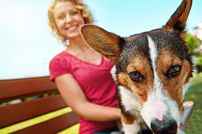 Buy stock photo Shot of a young woman bonding with her dog in the park